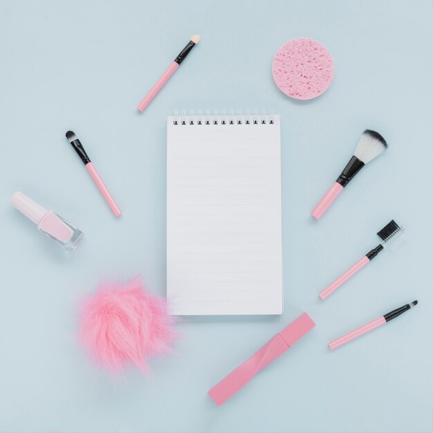 Flat lay assortment with make-up brushes and notebook