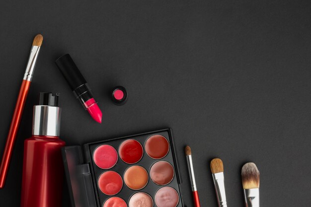 Flat lay assortment with make-up products on black background