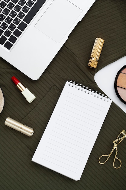 Flat lay assortment with make-up products and laptop