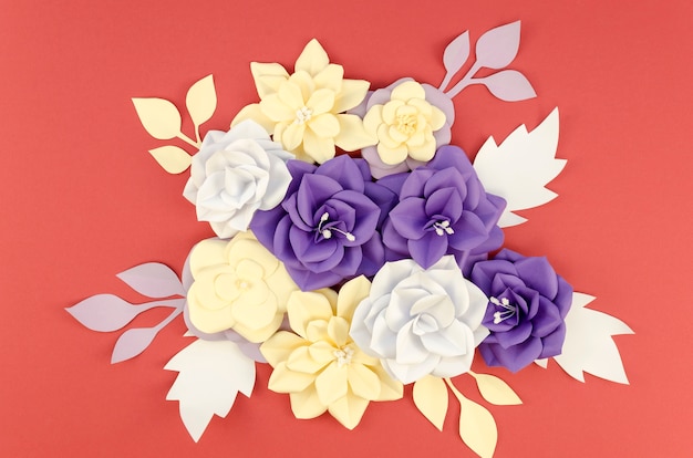 Flat lay assortment with paper flowers and red background