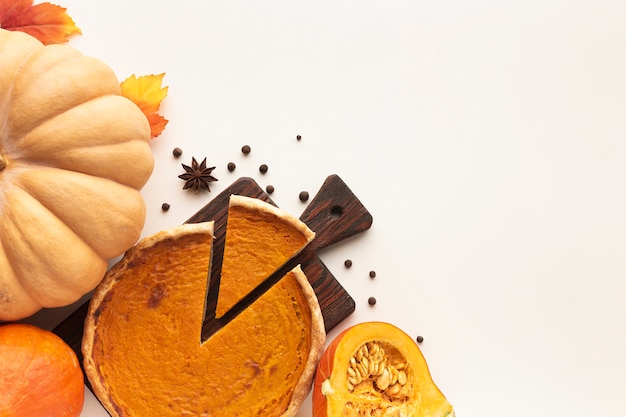 Flat lay assortment with sliced pie and pumpkin