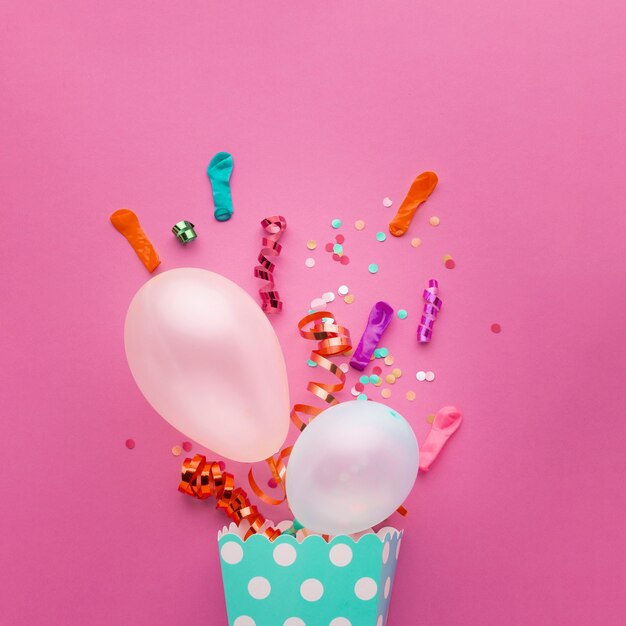 Flat lay assortment with with white balloons and confetti