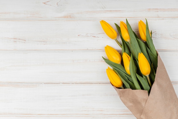 Foto gratuita assortimento piatto di tulipani gialli con spazio di copia