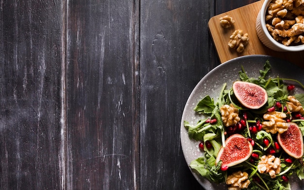 Плоская планировка осеннего инжирного салата на тарелке с грецкими орехами и копией пространства