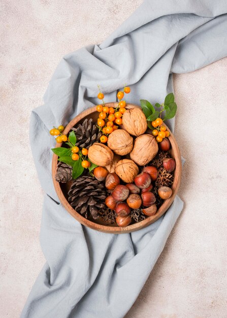 Flat lay of autumnal bowl with pine cones and fabric