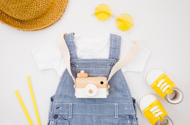 Flat lay baby clothes with photo camera