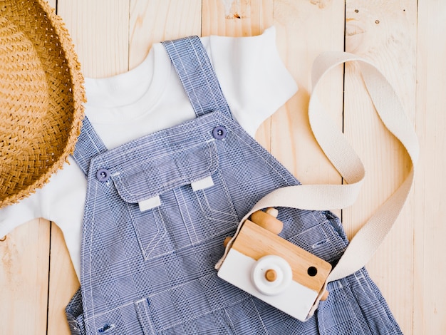Free photo flat lay baby clothes with photo camera