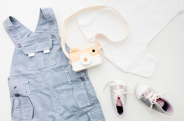 Flat lay baby clothes with photo camera