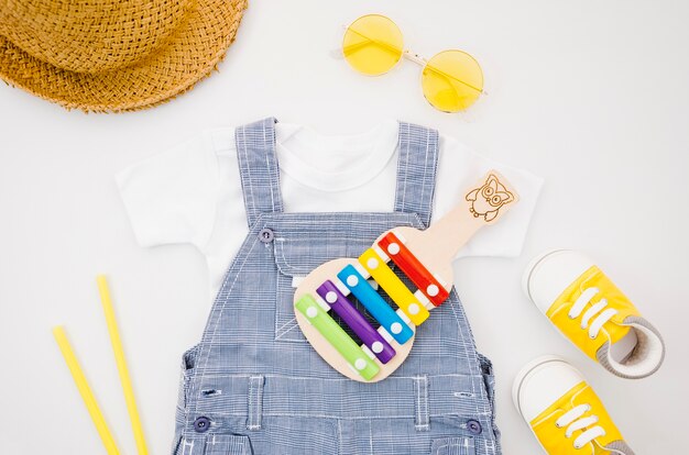 Flat lay baby clothes with xylophone