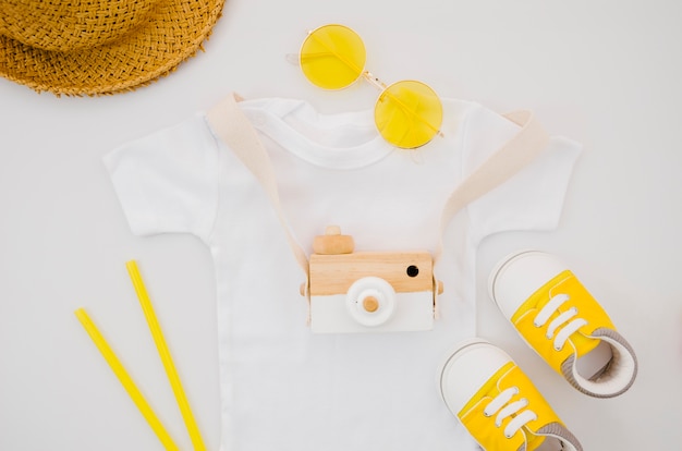 Flat lay baby t-shirt with photo camera