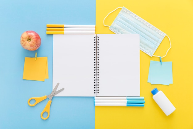 Flat lay of back to school materials with notebook and apple