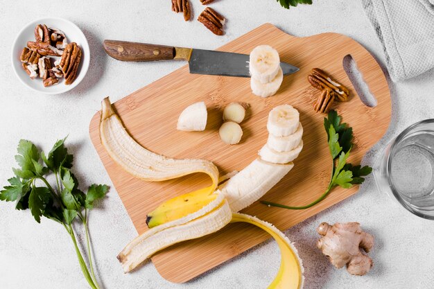 Flat lay of banana on chopping board with ginger