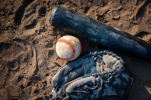 Free photo flat lay of baseball and bat in dirt