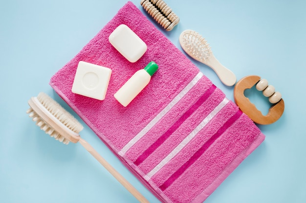 Flat lay of bath products on pink towel