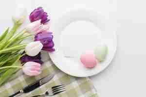 Foto gratuita disposizione piana dei tulipani meravigliosamente colorati con il piatto e le uova di pasqua