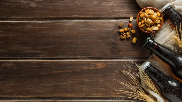 Free photo flat lay of beer bottles with nuts and copy space