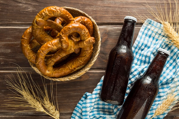 Free photo flat lay of beer bottles with pretzels and wheat