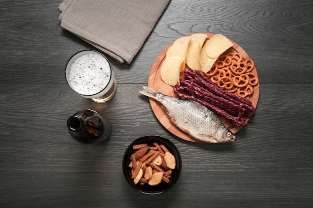 Flat lay beer glass and bottle with food platter