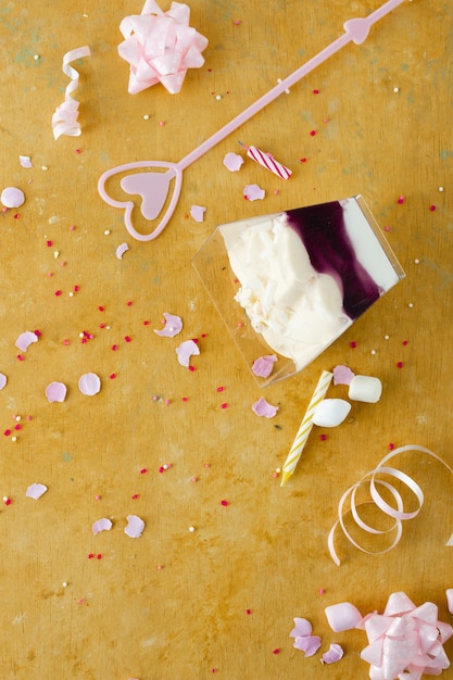 Flat lay of birthday cake with ribbon and marshmallow