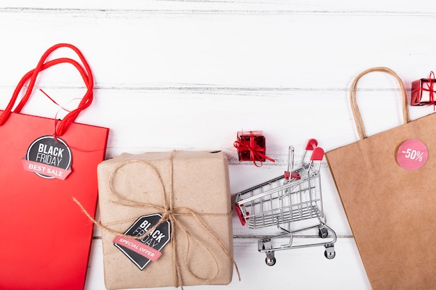 Free photo flat lay black friday gifts and shopping cart