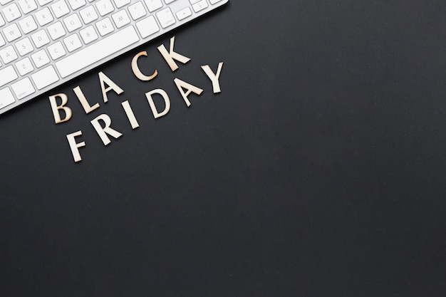 Flat lay black friday text near keyboard