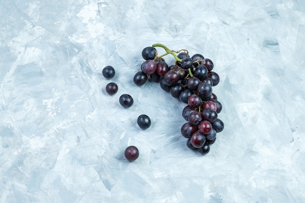 Flat lay black grapes on grungy plaster background. horizontal