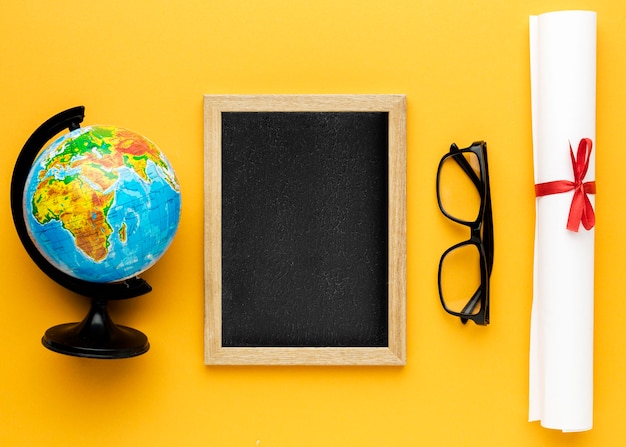 Free photo flat lay of blackboard with academic cap and glasses