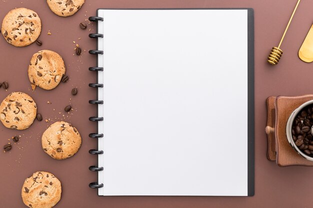 Flat lay of blank menu notebook with cookies