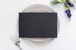 Free photo flat lay of blank menu paper on plates with forks and flowers