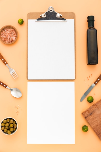 Free photo flat lay of blank menu paper with olives and cutlery