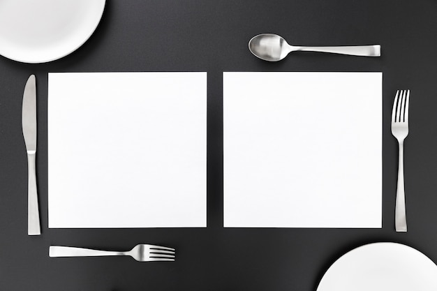 Free photo flat lay of blank menu papers with cutlery and plates