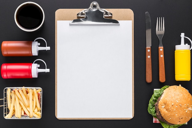 Flat lay of blank menu with burger and sauces