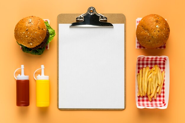 Flat lay of blank menu with french fries and burger