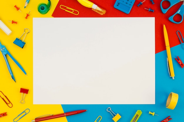 Flat lay of blank paper with office supplies background