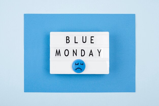 悲しい顔と青い月曜日のライトボックスのフラットレイ