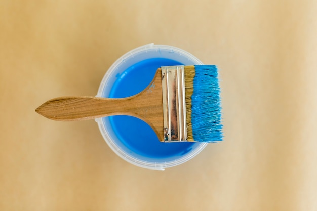 Flat lay of blue paint and paint brush