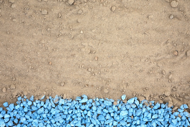 Free photo flat lay blue pebbles on sand
