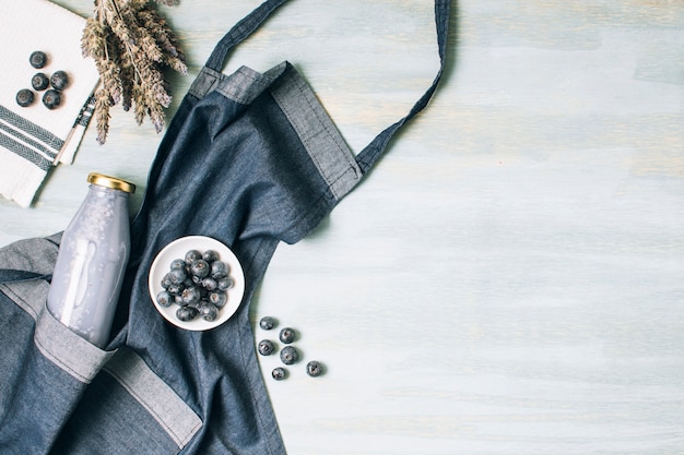 Flat lay blue smoothie and apron with copy space