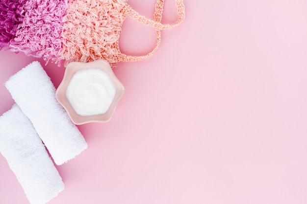 Flat lay of body butter on pink background with copy space