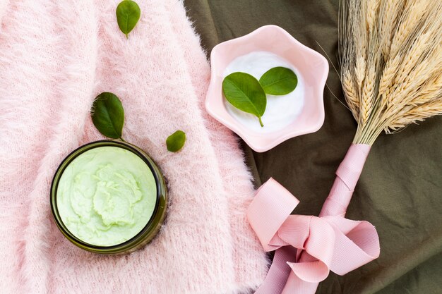 Flat lay of body butter on pink cloth