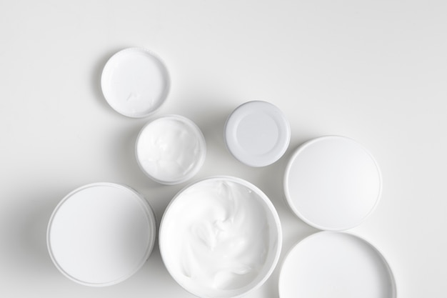 Flat lay body care containers on plain background