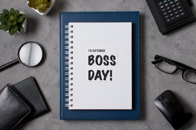 Flat lay boss's day arrangement with notepad