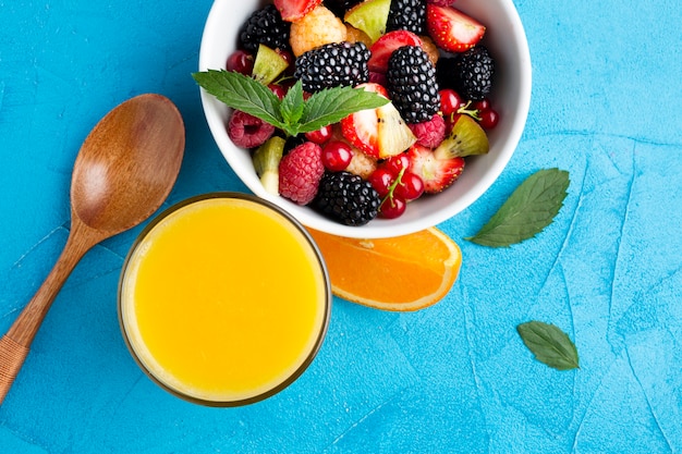 Flat-lay bowl of fresh berries and fruits with juice