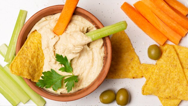 Flat lay bowl with humus and vegetables