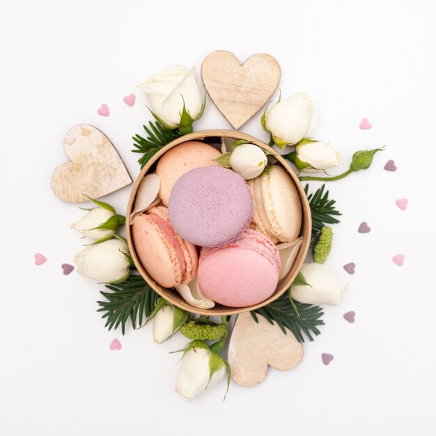 Flat lay of bowl with macarons and roses