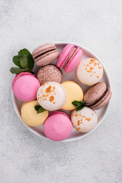 Foto gratuita piatto disteso di scodella con menta e macarons