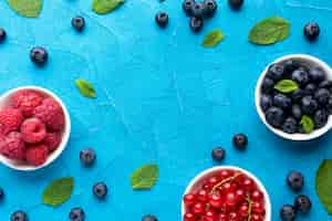 Free photo flat-lay of bowls of berries with copy space