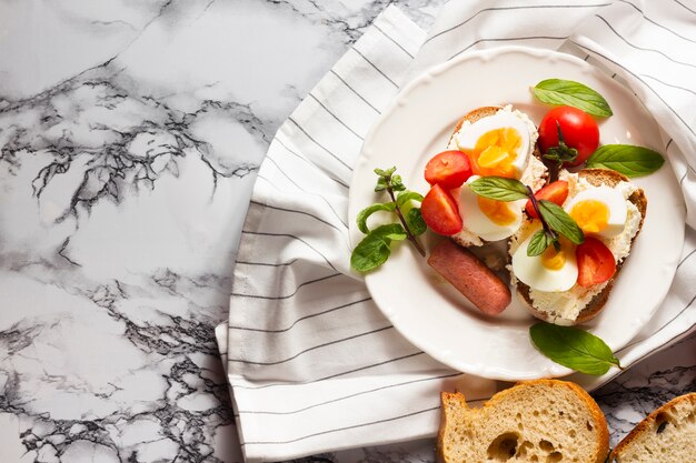 Flat lay bread with hard boiled eggs tomatoes and hotdog