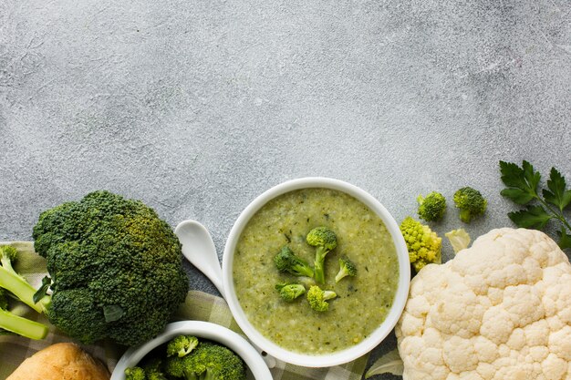 Flat lay broccoli bisque and cauliflower in bowl with copy space