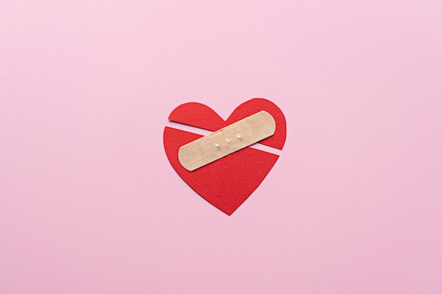 Free photo flat lay broken heart with band aid